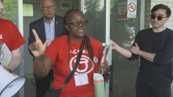 Monique Gordon devant une porte de l'immeuble en question.