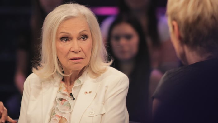Monique Mercure habillée en blanc avec ses cheveux longs blancs.