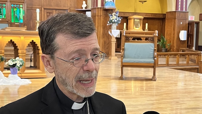 Mgr Michel Proulx interviewé dans l'église.