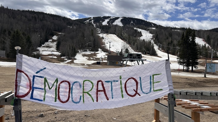 Une banderole devant le Mont Édouard de L'Anse-Saint-Jean.