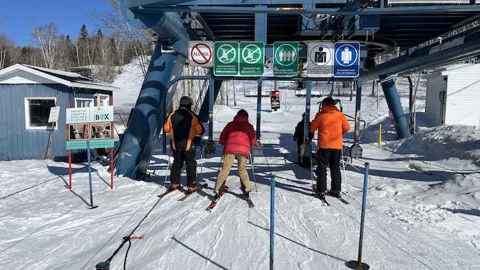 Des skieurs attendent le remonte-pente.
