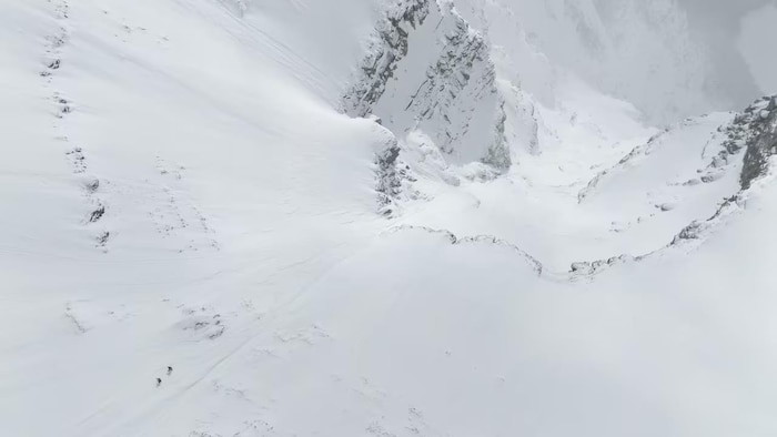 En regardant de près, on peut voir Lustenberger et Pierrel, en bas à gauche, en train d'escalader le mont Robson avant leur descente à ski. 