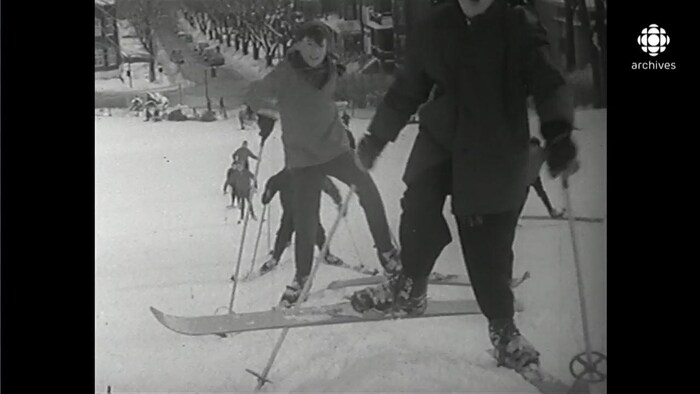 File de skieurs montant la pente enneigée du mont Royal à l'aide de bâtons