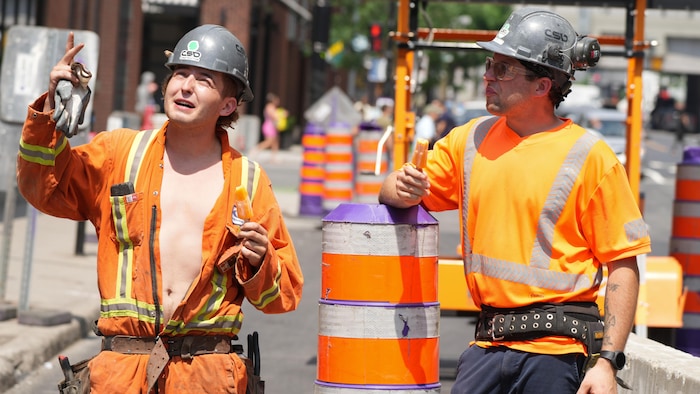 Des travailleurs de la construction mangent des popsicles pour lutter contre la chaleur. 