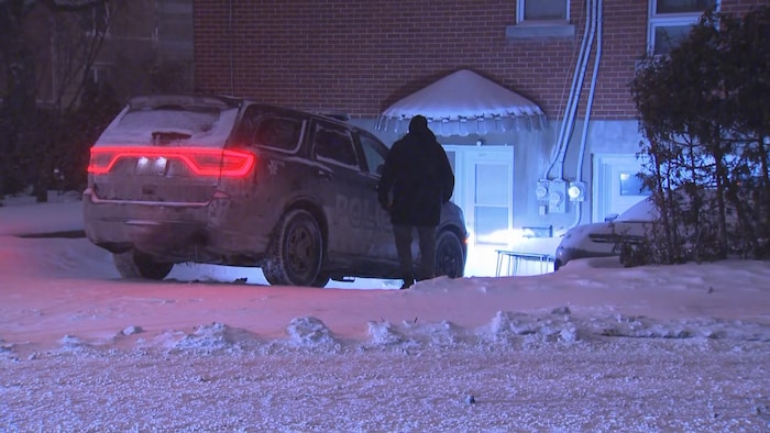 Une voiture de police stationnée dans l'entrée d'une maison.