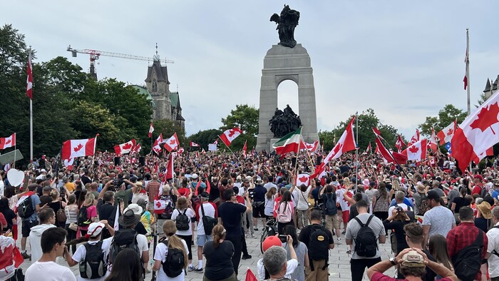 La foule autour du Monument commémoratif de guerre du Canada.