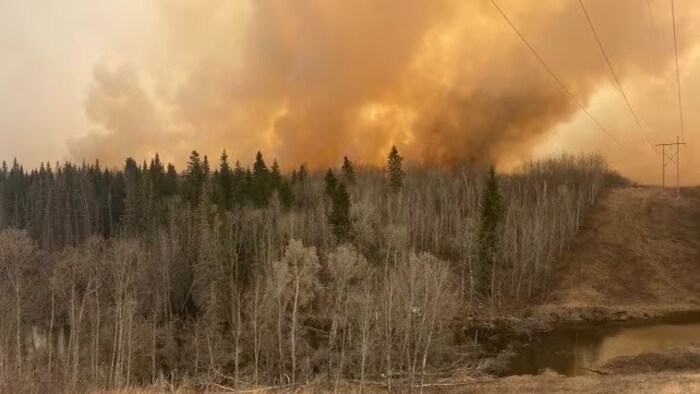 De la fumée s'élève du feu de forêt dans la Première Nation de Saulteaux, située à proximité de la ville de North Battleford.