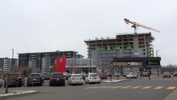 Un immeuble en construction à Lévis. Une fine couche de neige recouvre le sol.