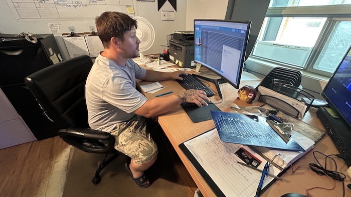 Matthew Murray-Raske assis à son bureau, en train de travailler sur un ordinateur.