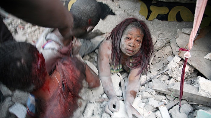 Une femme s'extrait des décombres du séisme qui a frappé Haïti le 12 janvier 2010.