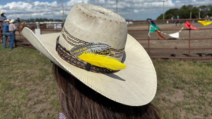 Une plume jaune sur un chapeau.