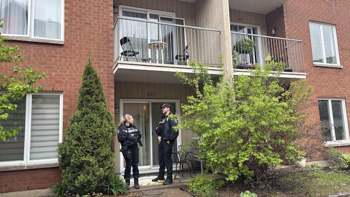 Des policiers font le guet devant le logement où la dame a été retrouvée sans vie, dans le quartier Saint-Roch.