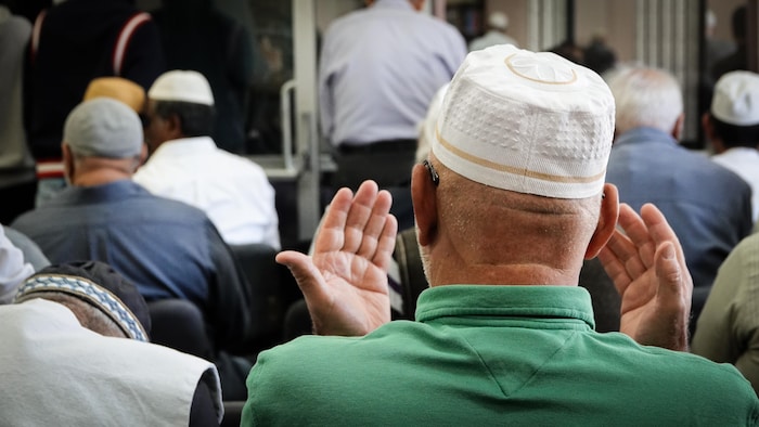 Un homme prie dans une mosquée.
