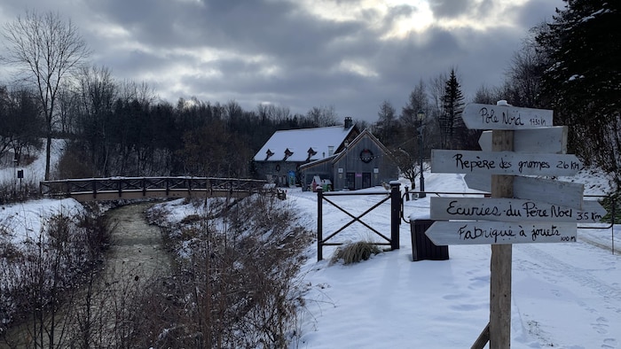 Flèches indiquant le chemin pour le Pôle Nord, le Repère des gnomes, les Écuries du Père Noël et la Fabrique à jouets devant le Moulin Michel.