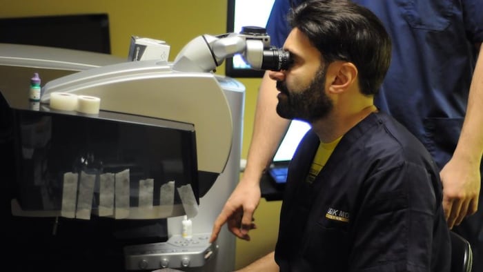 Un médecin durant une opération des yeux.