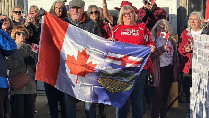 Des personnes présentent un drapeau.