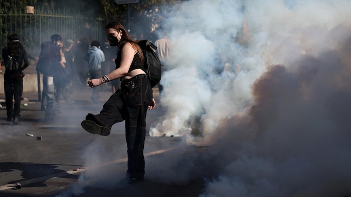 Une étudiante masquée est entourée de fumée.