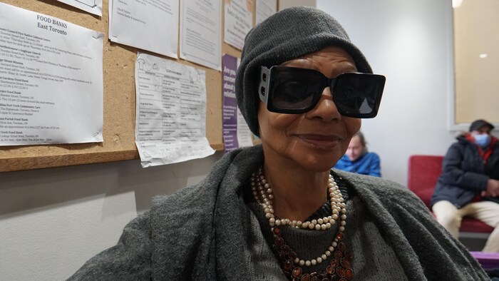 Elle pose pour une photo avec des lunettes fumées dans une salle d'attente.