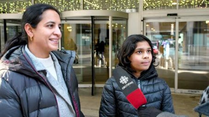 Munazza Kazi et son fils Zain devant les portes du Centre Eaton de Toronto.