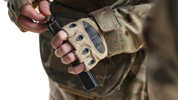 Un paramilitaire ukrainien insère des munitions dans le chargeur de son fusil d'assaut, le 22 février 2023.