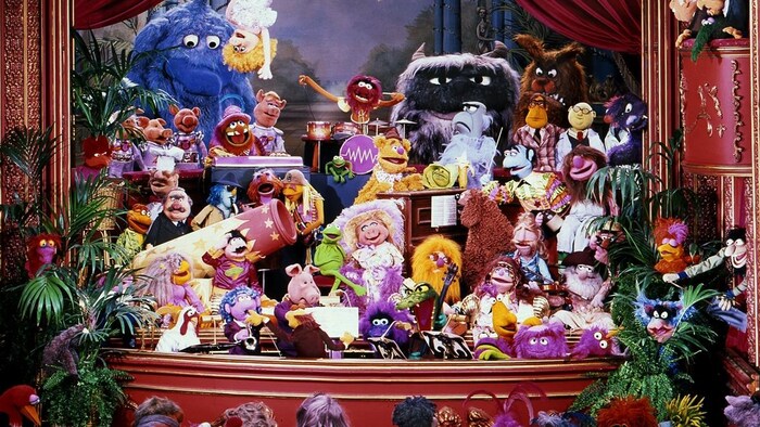 Des dizaines de marionnettes sont sur une scène.