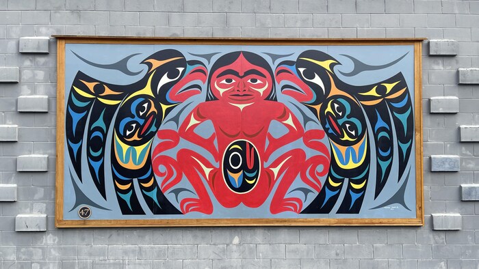 Une murale sur laquelle il y a des personnages et motifs autochtones.