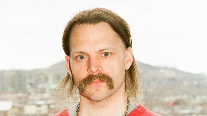 Portrait de l'homme devant un paysage.