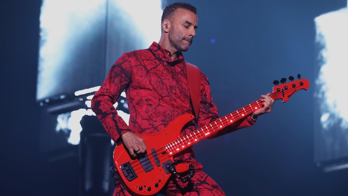 Un homme avec une guitare sur une scène.