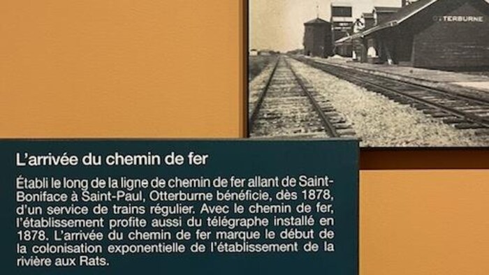 Une photo du chemin de fer et un texte descriptif sur le mur du musée de Saint-Pierre-Jolys.