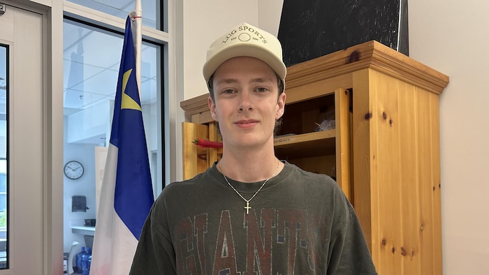 Connor Broussard est debout à l'entrée du musée. 