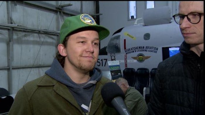 Ted Siddons et son ami Shawn Martins répondent aux questions de la journaliste Geneviève Patterson au Musée de l'aviation de la Saskatchewan, à Saskatoon. 