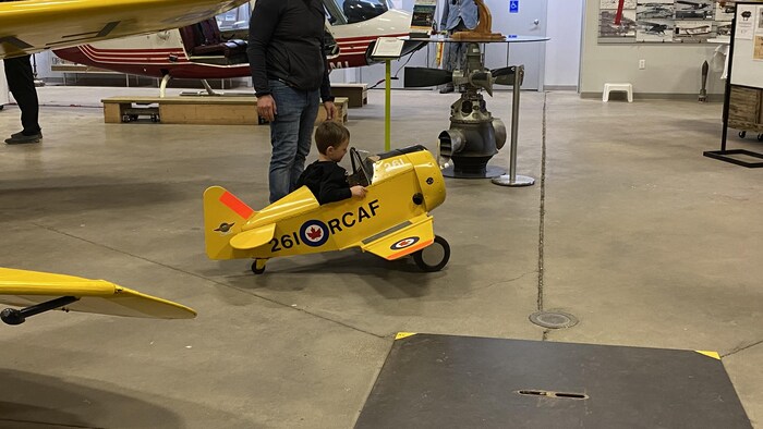 Un petit garçon à bord d'un avion pour enfants au sol, au Musée de l'Aviation de la Saskatchewan, à Saskatoon. .