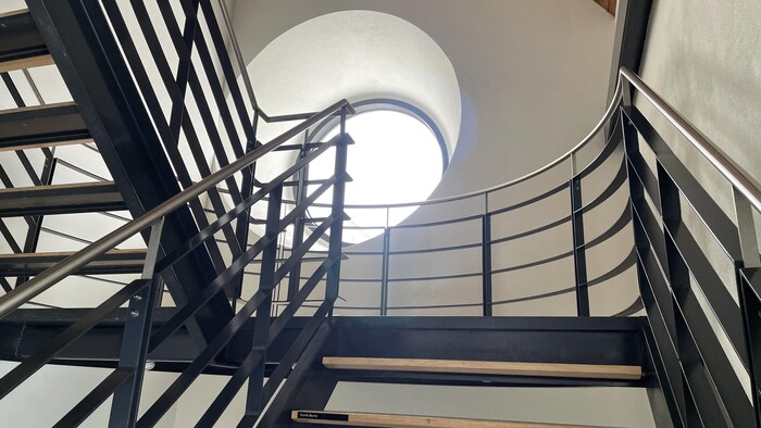 Une fenêtre ronde dans une cage d'escalier.