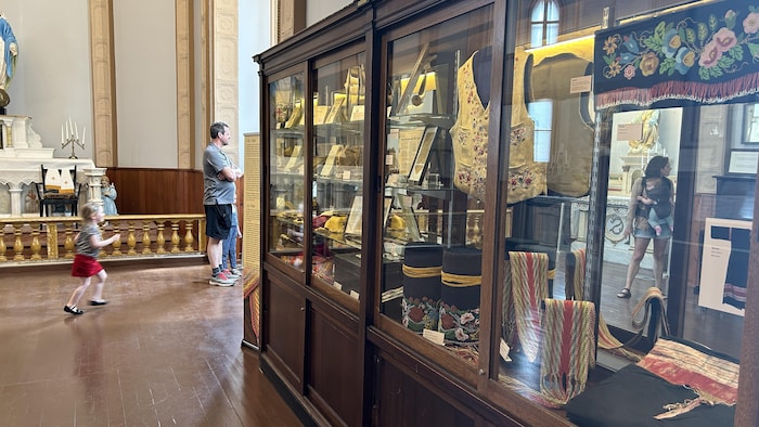 Des visiteurs près d'une armoire vitrée au Musée de Saint-Boniface, le 27 mai 2023.