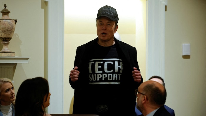 Elon Musk, qui porte une casquette noire à l'effigie du message de campagne de Donald Trump, «Rendons sa grandeur à l'Amérique», ouvre son veston sur un t-shirt disant «soutien technique».