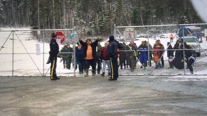 Les manifestants franchissent les portes en faisant des signes de victoire.