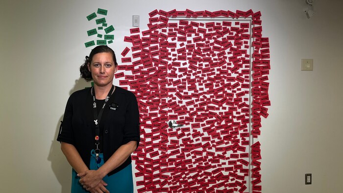 Mylaine Paquette devant des papiers où on peut lire "oui" ou "non".