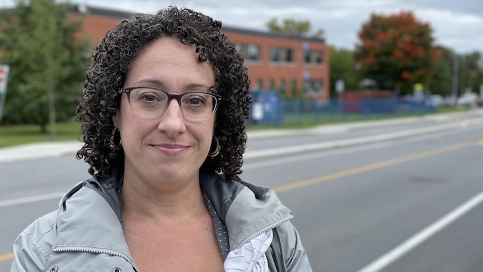 Mylène Leroux sourit devant un édifice.