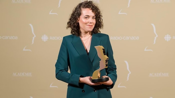 Une femme tient un trophée dans ses mains.