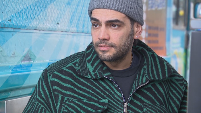 Un homme dans la trentaine au regard lointain avec un bonnet.