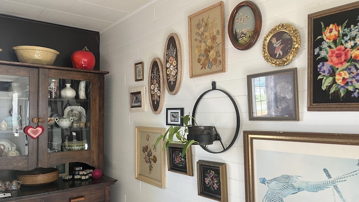 Des tableaux et des décorations d'époque sont accrochés sur les murs du salon chez Nadine Fournier.