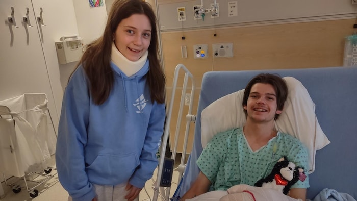 Olivier Morel est assis dans un lit d'hôpital. Il a le bras gauche et la main dans un bandage. Marguerite Morel a le cou immobilisé près de lui.