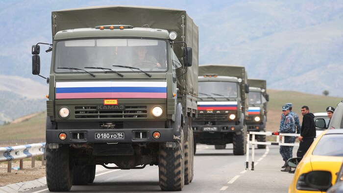 Des véhicules de soldats de la paix russes quittant la région azerbaïdjanaise du Haut-Karabakh pour l'Arménie passent un poste de contrôle arménien sur une route près du village de Kornidzor, en Arménie, le 22 septembre 2023.