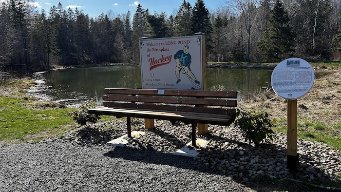 Deux affiches sont installées près d'un banc et d'un étang. 