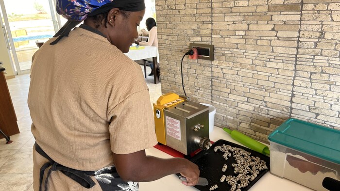 Une femme devant un petit four. 