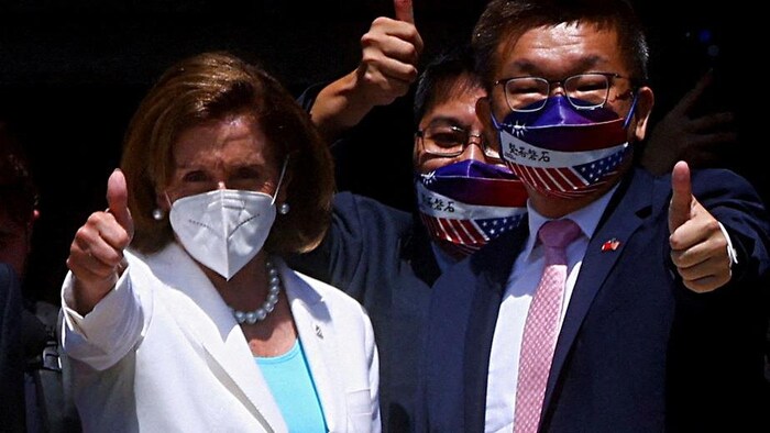 Nancy Pelosi lève le pouce en l'air en compagnie de deux officiels taïwanais.