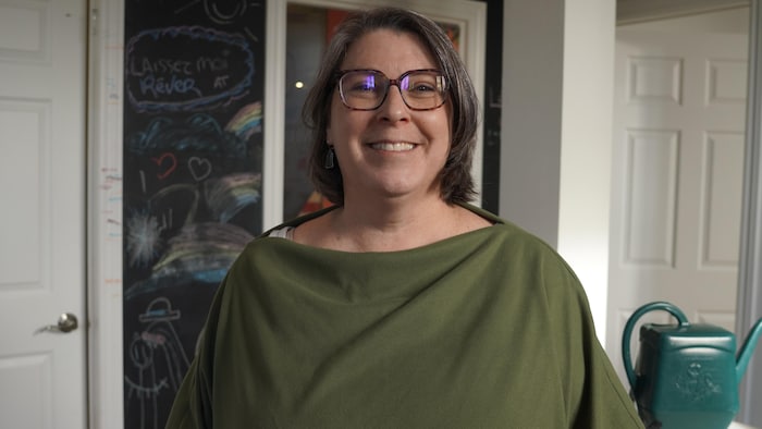 Nancy Renaud pose devant un tableau à dessin.
