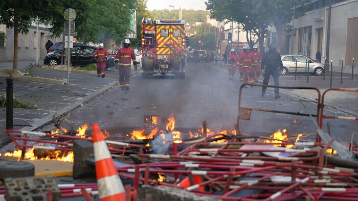 Des pompiers viennent éteindre des incendies après une manifestation à Nanterre.