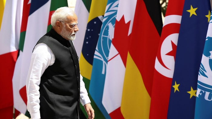 Narendra Modi passant devant des drapeaux de plusieurs nations.