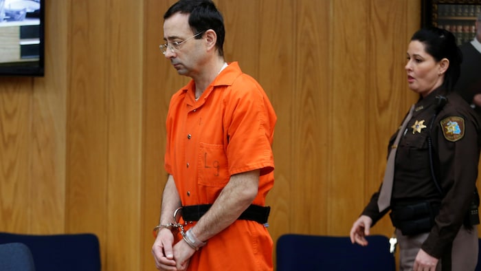 Il est vêtu de sa combinaison orange de prisonnier au tribunal.